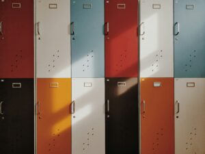 Colored lockers with light shining off of them, all closed.