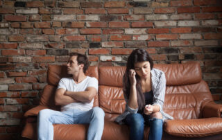 Distanced couple sitting on a couch illustrating anxious avoidant attachment style and relationship tension