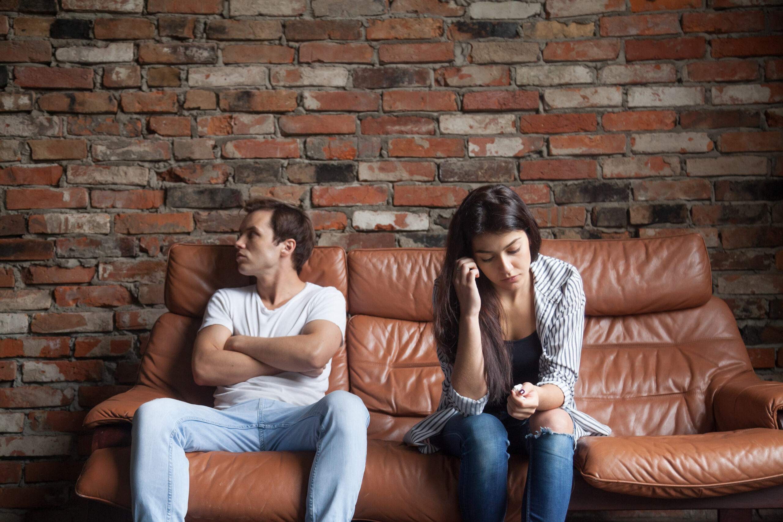 Distanced couple sitting on a couch illustrating anxious avoidant attachment style and relationship tension